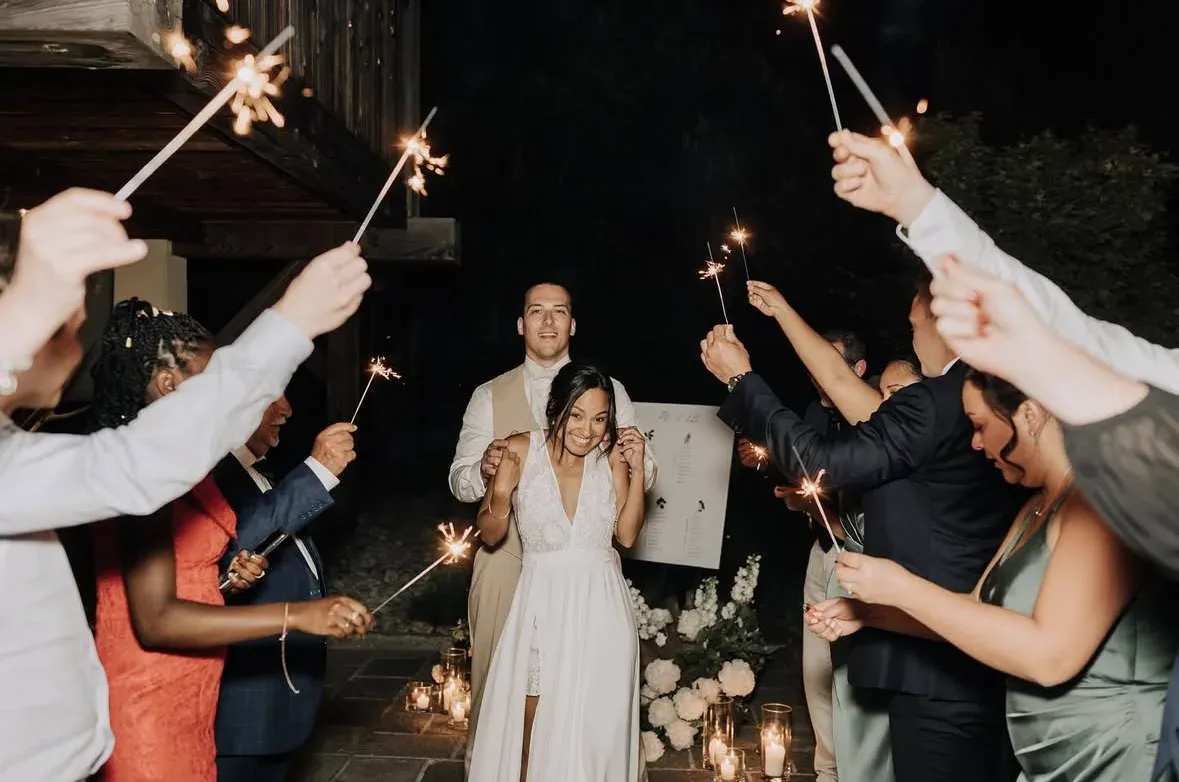 Les mariés arrivent de nuit entre deux haies d’invités qui lèvent des cierges magiques ; la mariée rit, le marié juste derrière elle